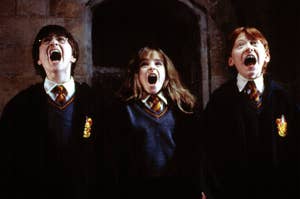 Daniel Radcliffe, Emma Watson, and Rupert Grint, in Hogwarts robes, screaming in a scene from Harry Potter