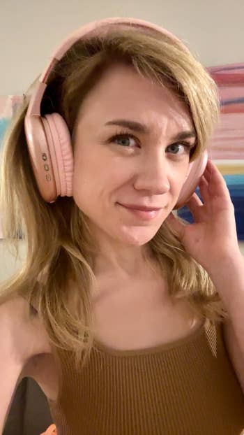 Person wearing pink over the ear headphones 