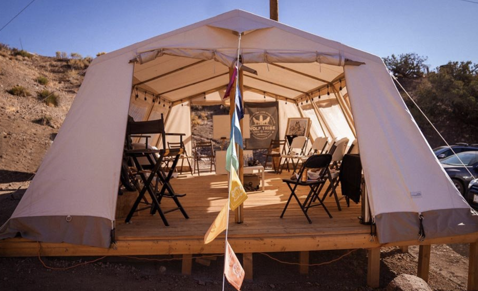 A tent outdoors on an elevated surface and with many seats inside