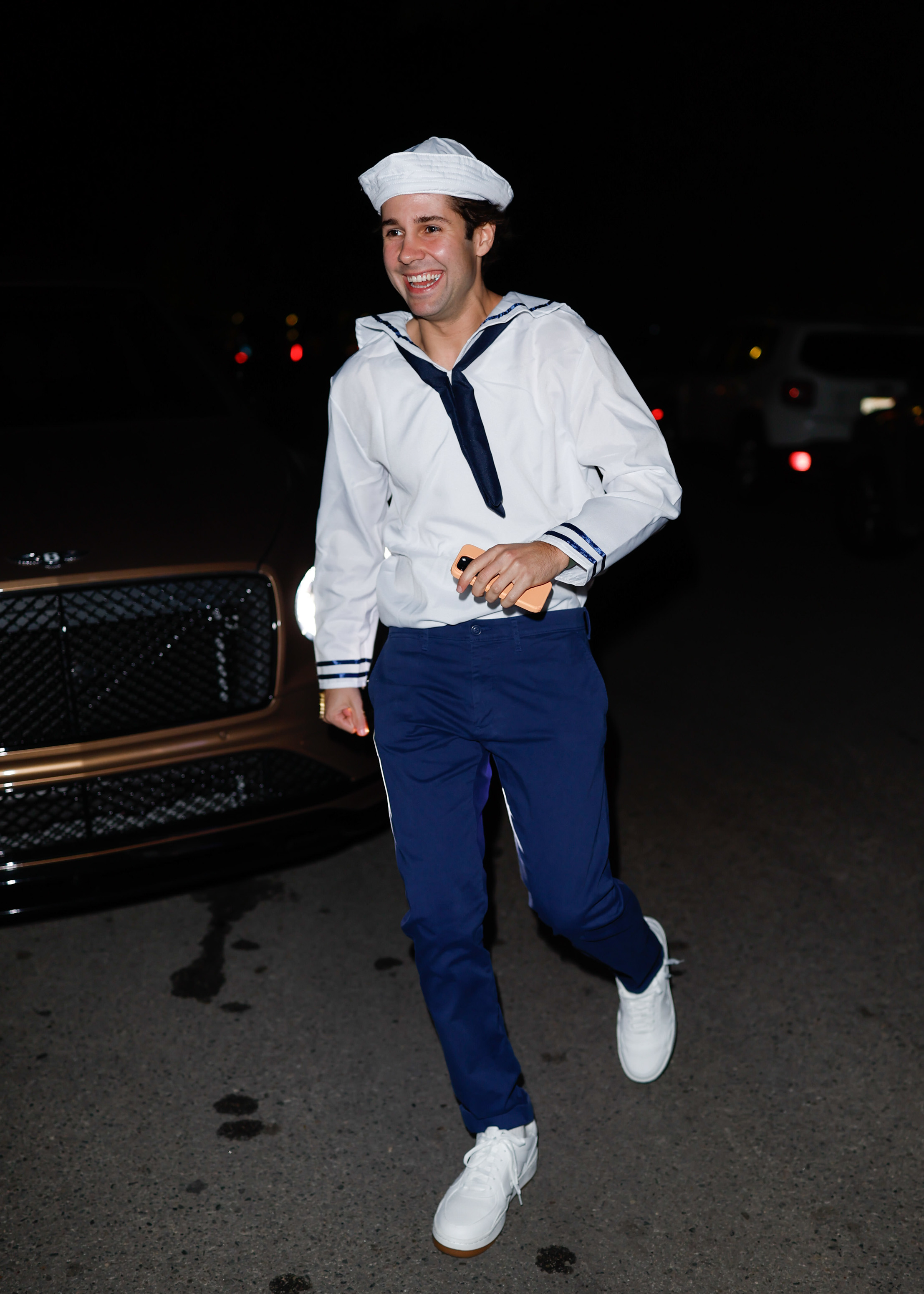 David Dobrik wearing a sailor costume with a hat while walking outside