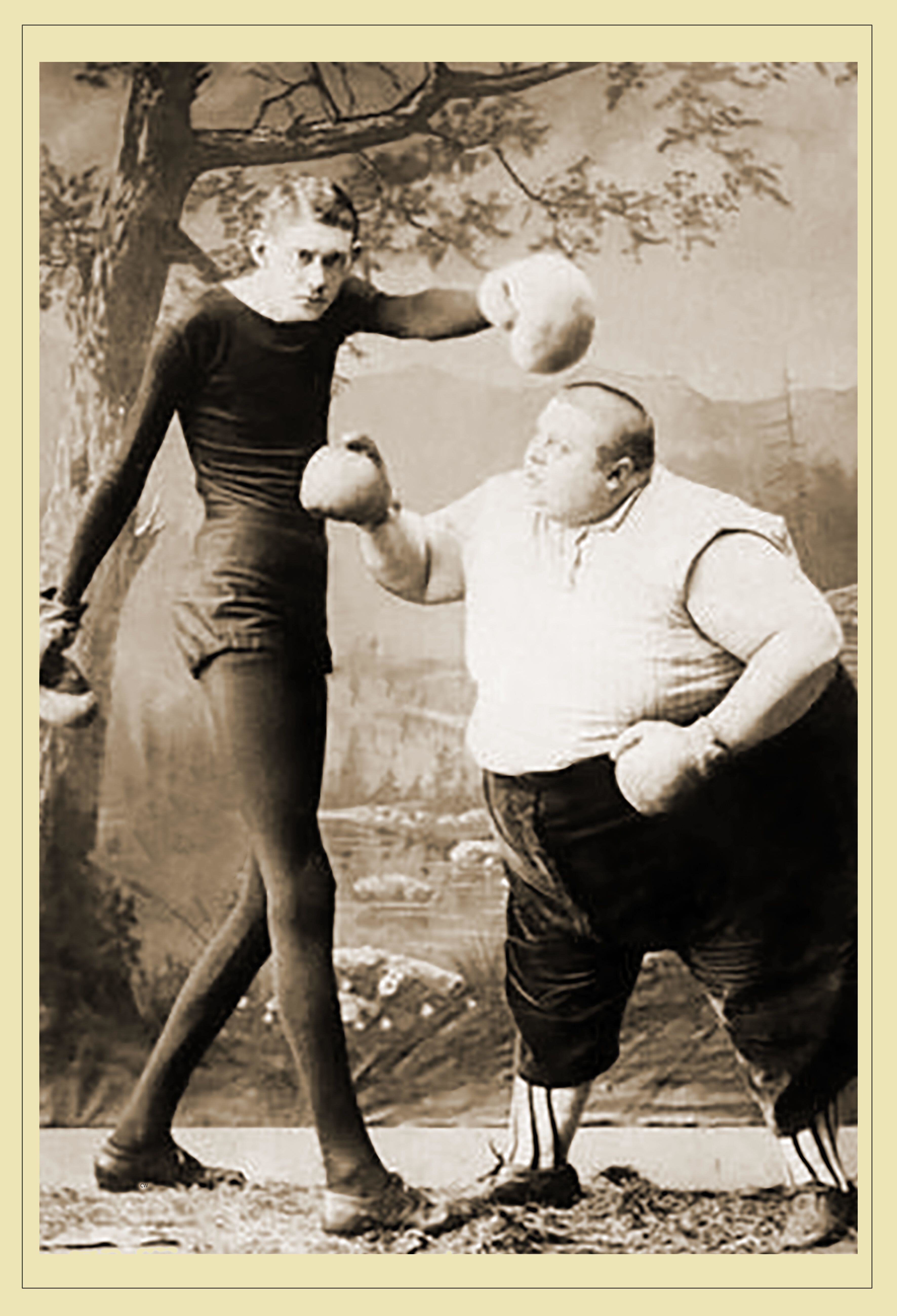 Two boxers, a very tall and thin man and a much shorter and heavier man, pose in vintage boxing attire in front of a painted backdrop