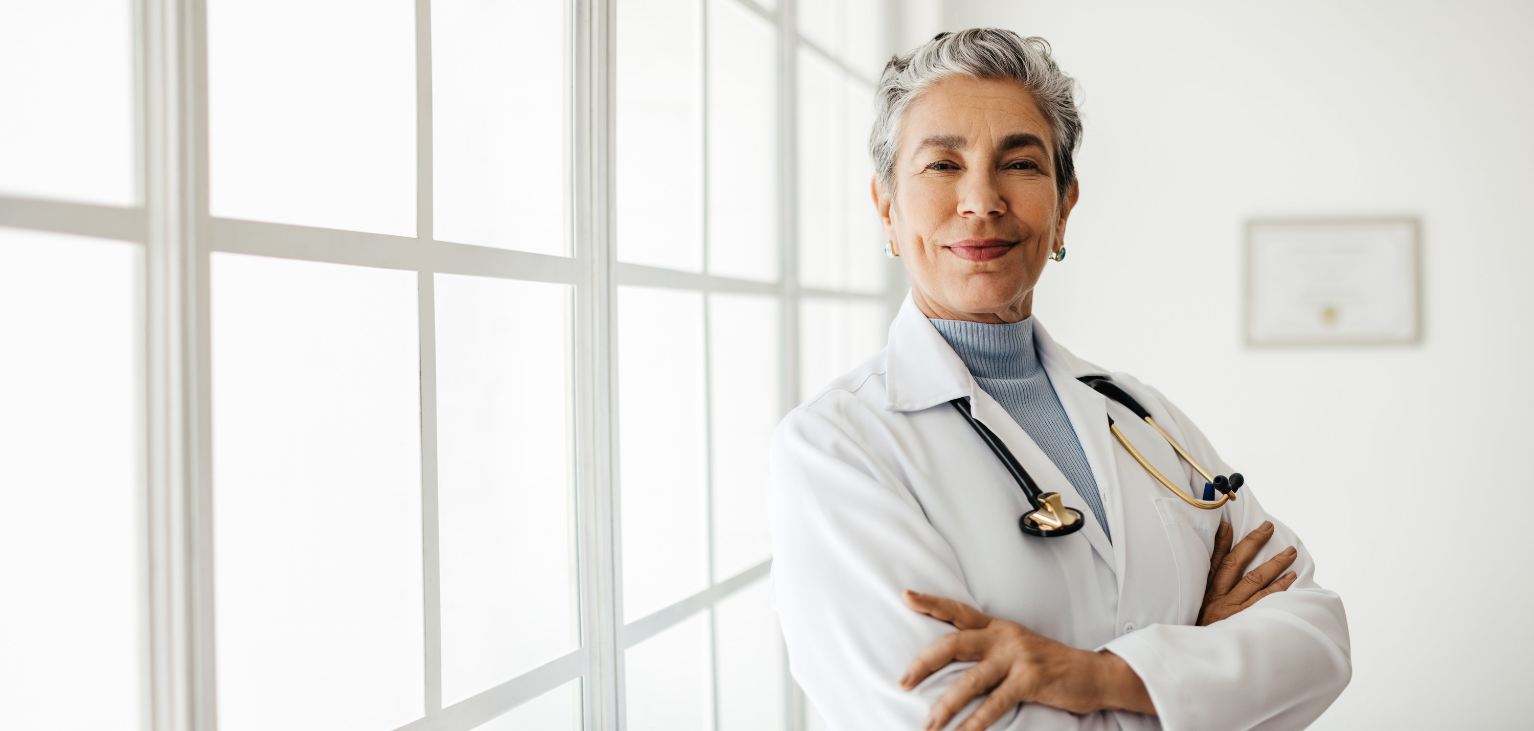 A doctor with arms crossed and smiling