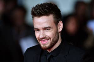 Liam Payne in a black suit smiling at a formal event