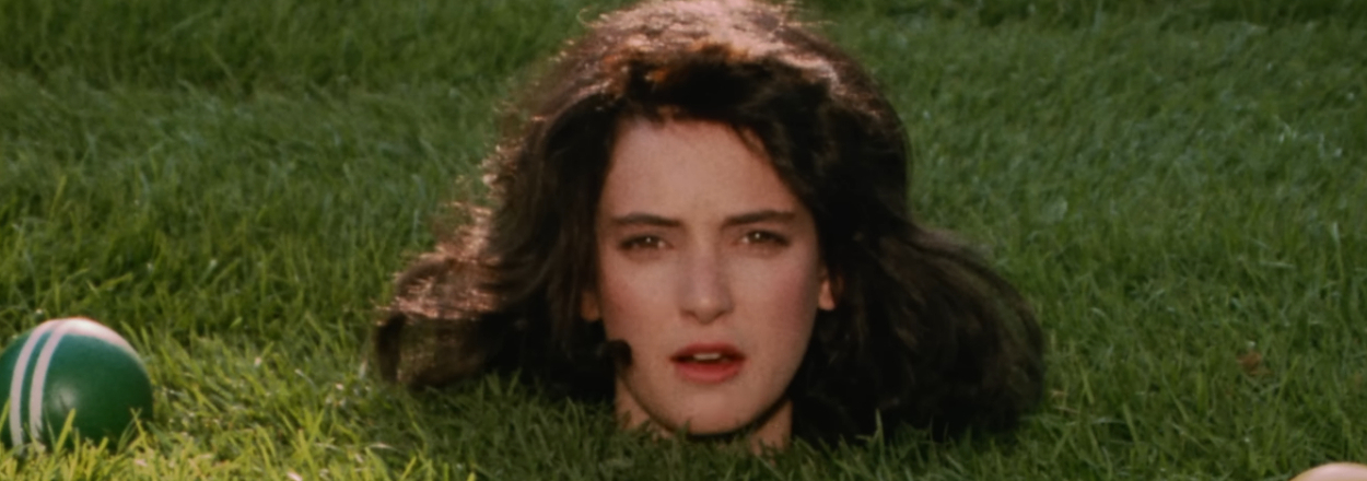 Winona Ryder's head in the grass near croquet balls as Veronica in Heathers